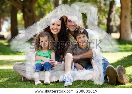 Happy family sitting in the garden against house outline in clouds