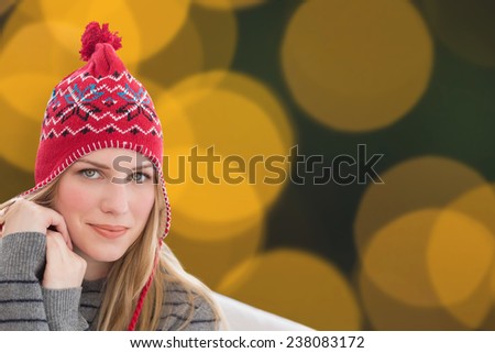 Woman sitting on couch against blurry yellow christmas light circles