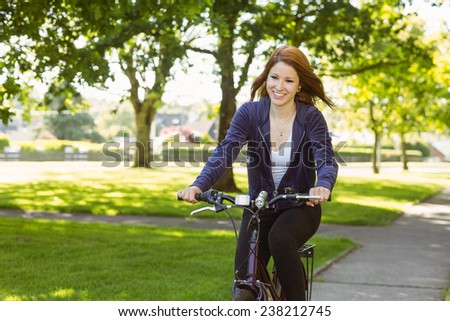 Pretty redhead cycling a bike on a sunny day