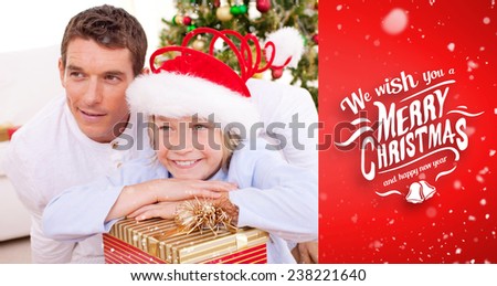 Smiling father and his son holding Christmas gifts against red vignette