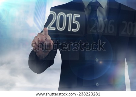 Businessman in suit pointing finger against 2015 on interface