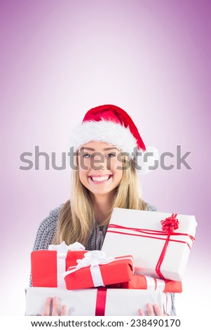 Festive blonde holding pile of gifts on vignette background