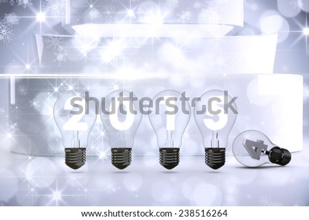 2015 with light bulb against lights twinkling in modern room