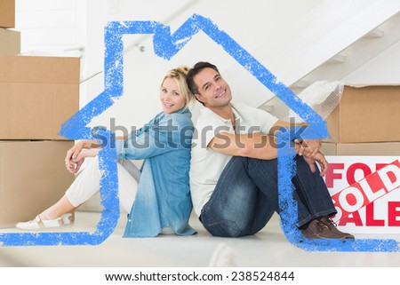 Smiling couple with boxes in a new house against house outline
