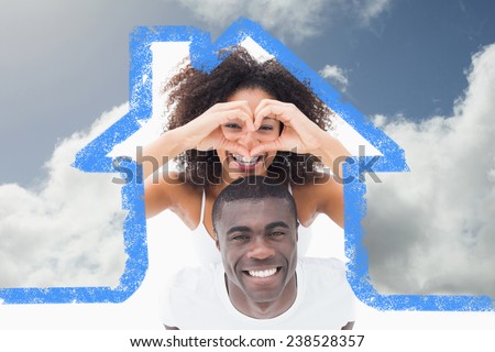 Attractive couple in matching clothes smiling at camera against bright blue sky with clouds