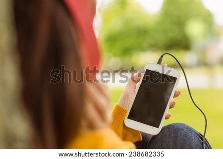 Close up of relaxed young woman enjoying music in the park