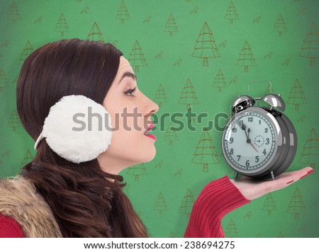 Brunette in winter clothes with hand out against green christmas tree pattern