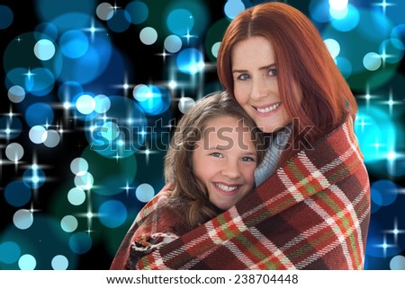 Mother and daughter under blanket against blue glowing dots design pattern