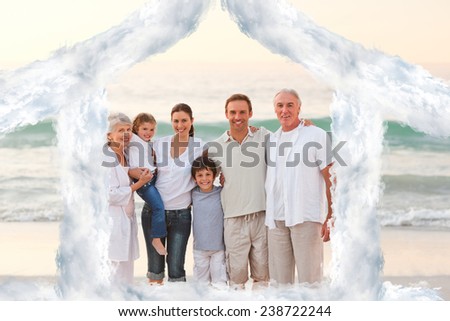 Beautiful family at the beach against house outline in clouds