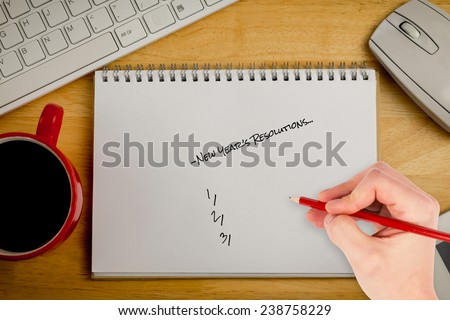 Composite image of hand writing new years resolutions against overhead of notepad and coffee