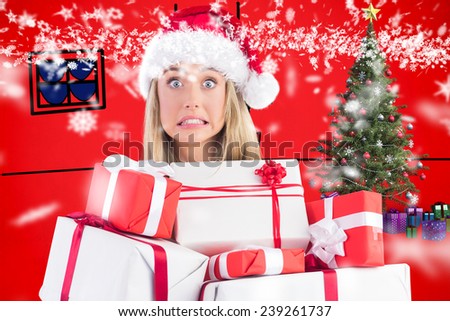 Festive blonde holding pile of gifts against red background