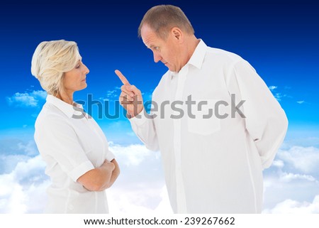 Angry man pointing at his partner against bright blue sky over clouds