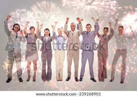 Happy business team raising their arms against colourful fireworks exploding on black background
