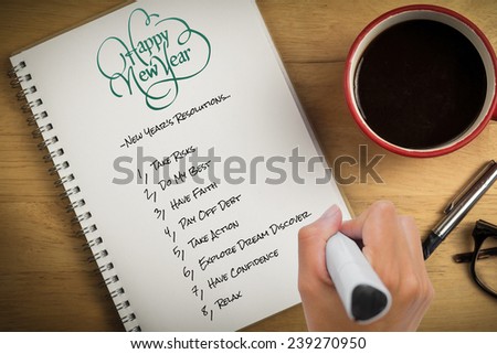 Hand writing with marker against overhead of notepad and pen and coffee