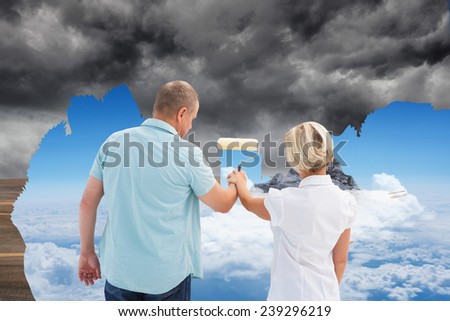 Composite image of happy older couple painting the sky from dark to light