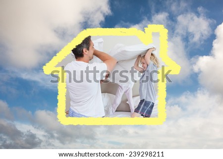 Family having a pillow fight against blue sky with white clouds