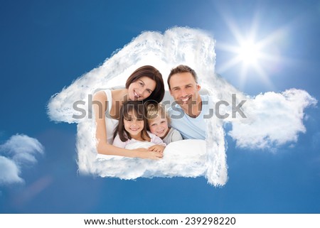 Lovely family sitting together on the bed against bright blue sky with clouds