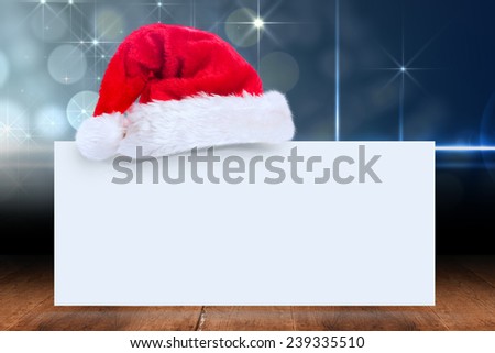 Santa hat on poster against shimmering light design over boards