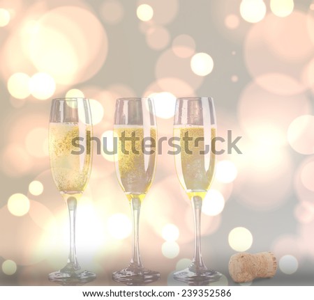 Close up of a cork against three full glasses of champagne