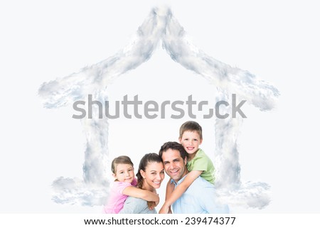 Cheerful young family looking at camera together against house outline in clouds