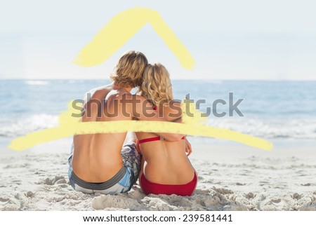 House outline against rear view of a young couple sitting on the beach