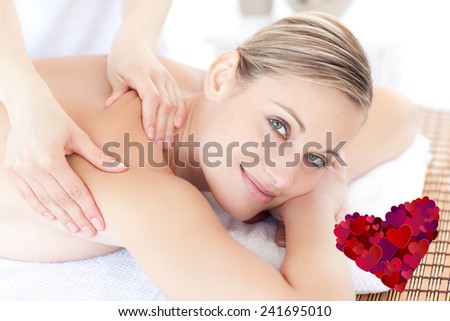 Smiling woman receiving a back massage against heart