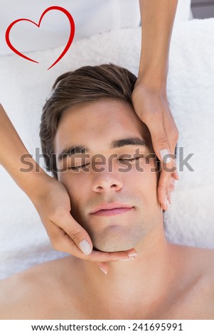 Man receiving facial massage at spa center against heart