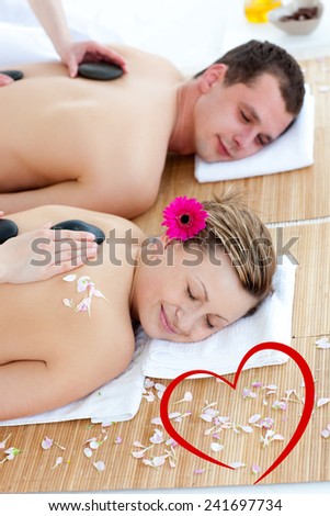 Young couple enjoying a back massage with stone against heart