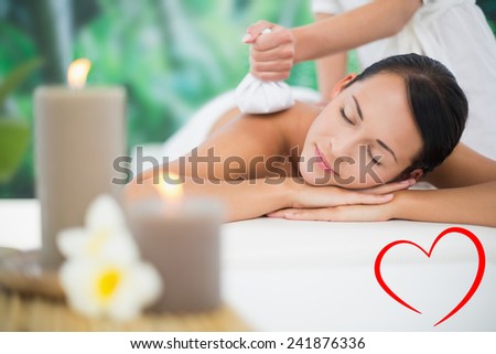 Beautiful brunette enjoying a herbal compress massage against heart
