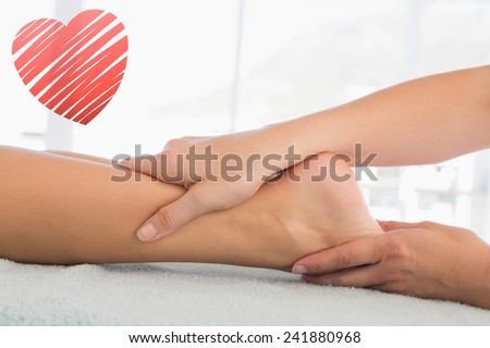 Woman receiving leg massage at spa center against red heart