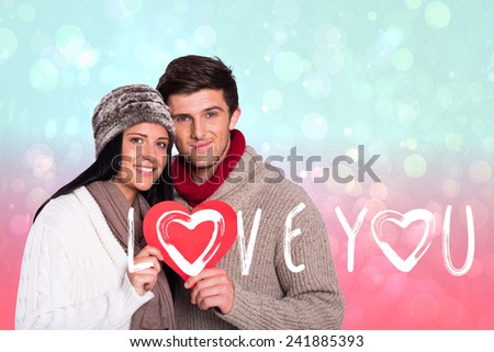 Young couple smiling holding red heart against blue and pink light spot design