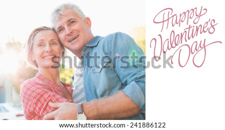 Happy mature couple hugging in the city against cute valentines message