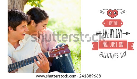 Woman laughing with her friend who is playing the guitar against cute valentines message