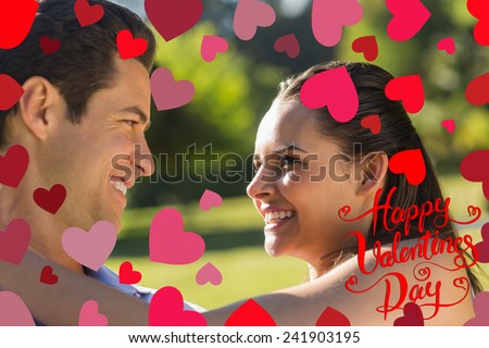 Loving and happy couple looking at each other at park against happy valentines day