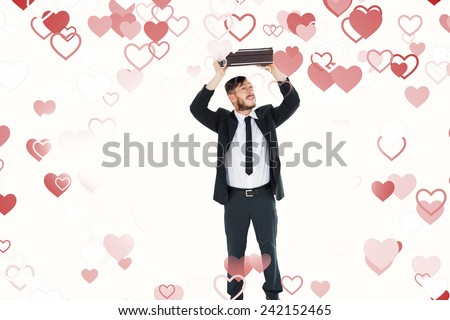 Geeky businessman holding briefcase over head against valentines heart design