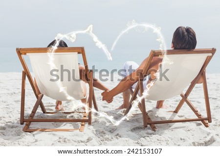 smoke heart against couple lying on deck chairs