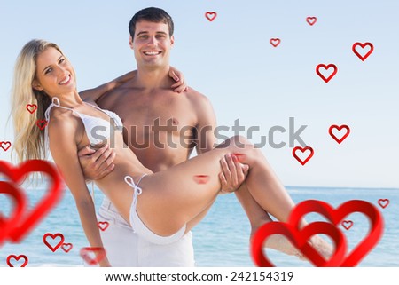 Man carrying his pretty girlfriend smiling at camera against hearts
