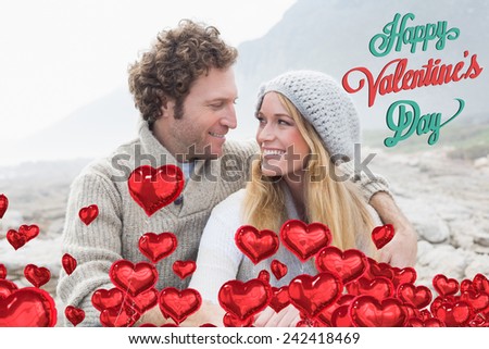 Happy couple sitting together on rocky landscape against cute valentines message