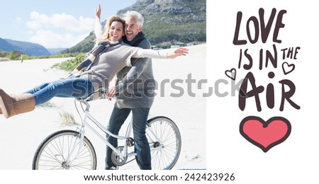 Carefree couple going on a bike ride on the beach against love is in the air