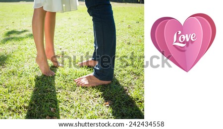 Couples bare feet standing on grass against love heart