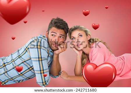 Attractive young couple lying and thinking against red vignette
