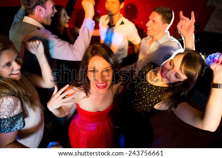 Happy friends dancing and smiling at the nightclub