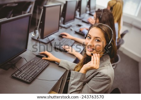 Smiling call centre agent talking on the headset in the office