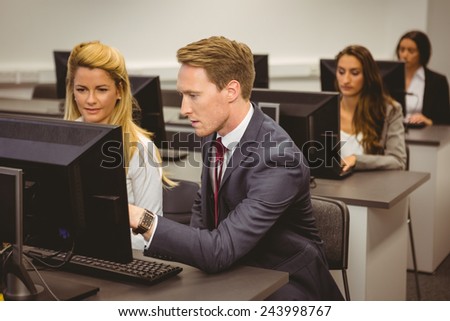 Boss talking and looking at laptop in the computer room