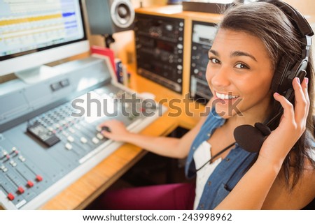 Smiling university student mixing audio in the studio of a radio