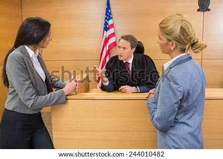 Lawyers speaking with the judge in the court room