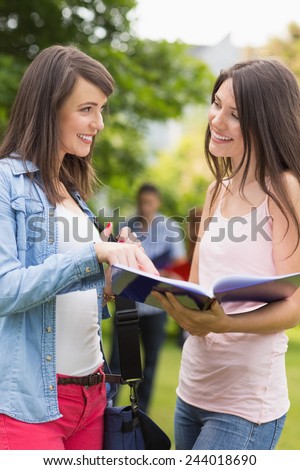 Pretty students reading from notepad at the university