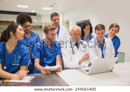 Medical students and professor using laptop at the university