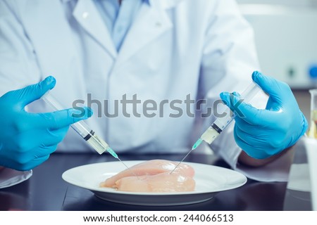 Food scientist injecting raw chicken at the university
