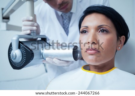 Serious young woman undergoing dental checkup in the dentists chair